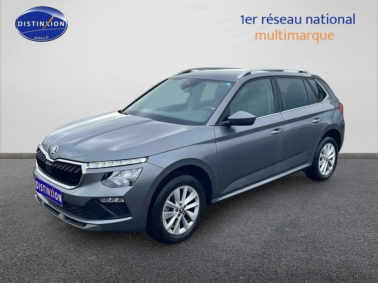 Vue 3/4 avant droite d'un Skoda Kamiq gris 2025 avec calandre chromée et jantes alu.