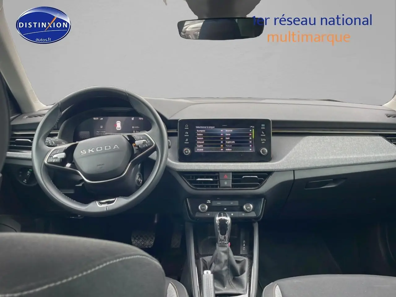 Vue intérieure avant du Skoda Kamiq gris 2025, tableau de bord moderne avec écran tactile et volant multifonction cuir.