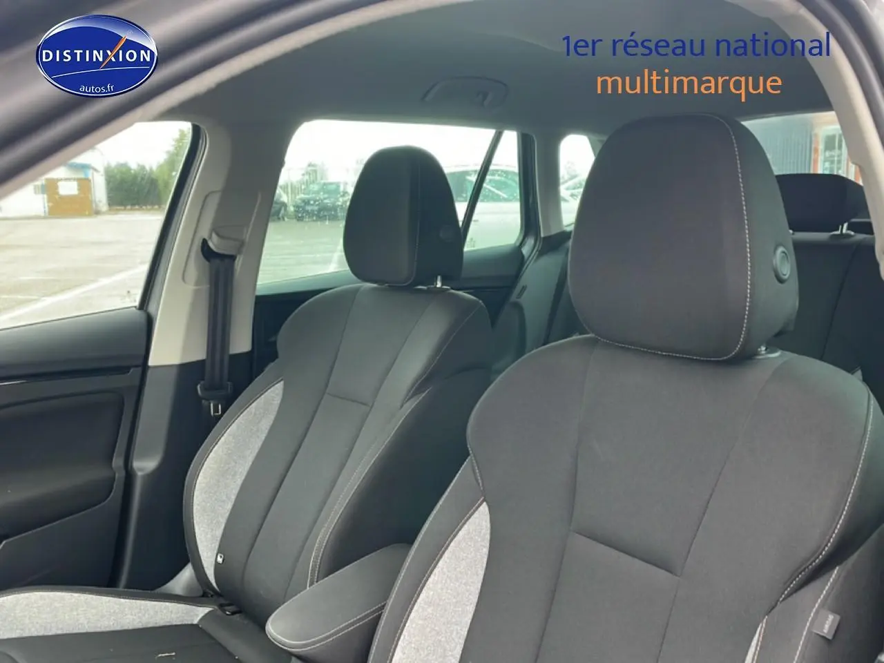 Vue intérieure des sièges avant gris clair et foncé du Skoda Kamiq 2025, avec accoudoir central et ceinture côté gauche visible.