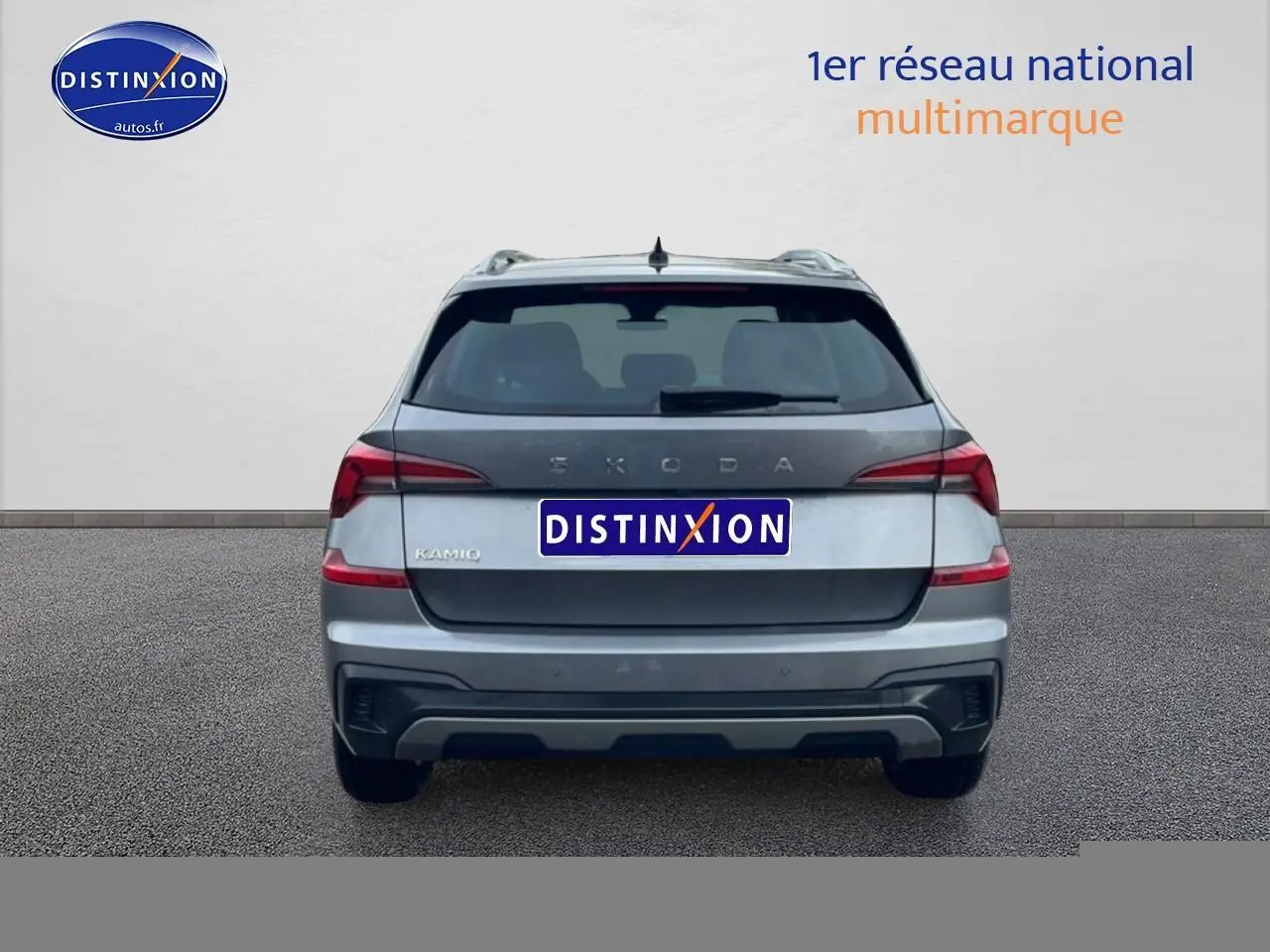 Vue arrière d'un Skoda Kamiq gris 2025 avec feux arrière LED et barres de toit visibles.