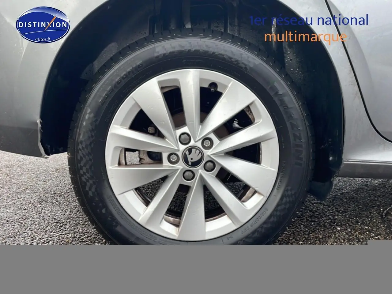 Gros plan sur la roue avant droite gris métallisé du Skoda Kamiq 2025 avec jante alu et logo Skoda au centre.