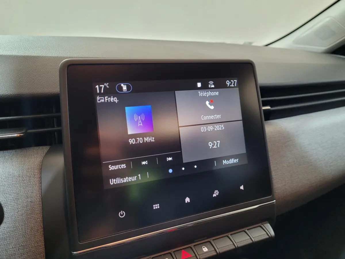 Écran tactile central de 7 pouces de la Renault Clio gris foncé, affichant radio et téléphone, vue intérieure de face.