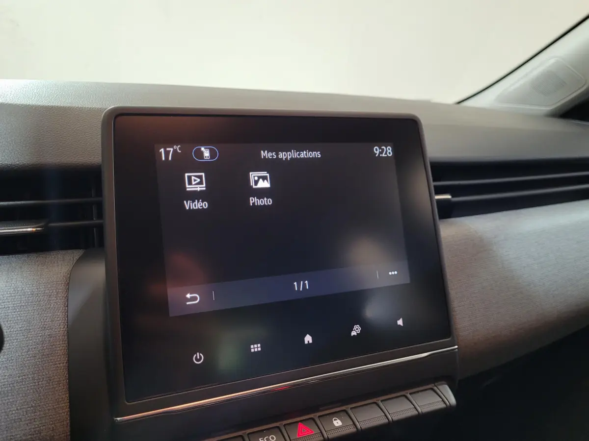 Écran tactile central affichant les applications vidéo et photo dans l’habitacle gris foncé d’une Renault Clio Evolution Blue dCi 100.