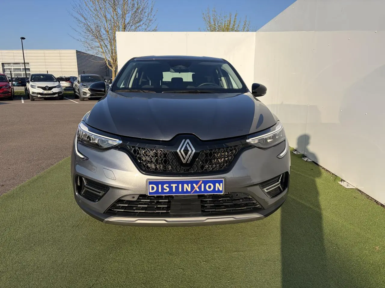Vue avant d'une Renault Arkana 2025 gris métallisé avec calandre noire et logo Renault centré.