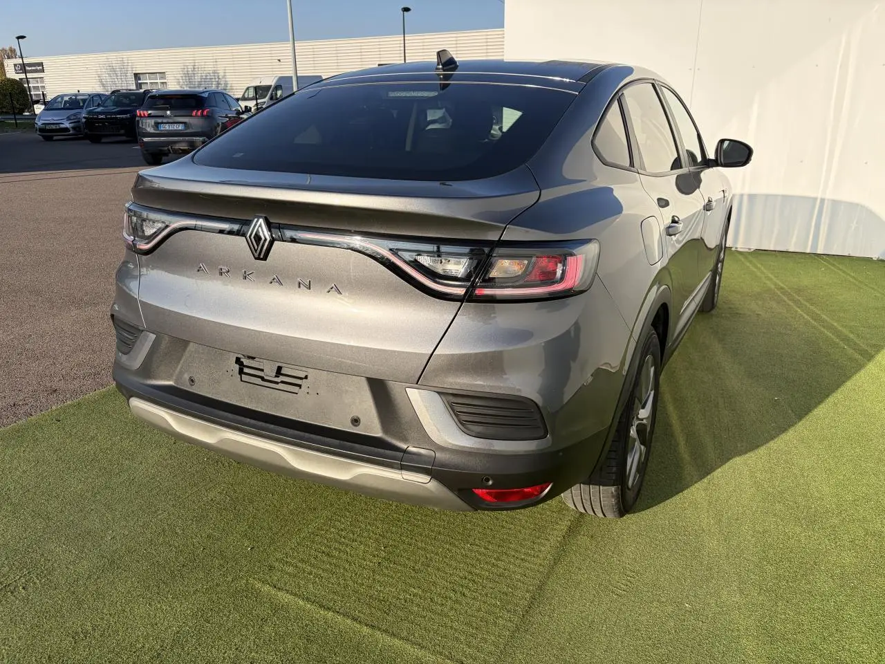 Vue 3/4 arrière droite d'une Renault Arkana gris métallisé 2025 avec feux LED et jantes alliage grises 17 pouces.