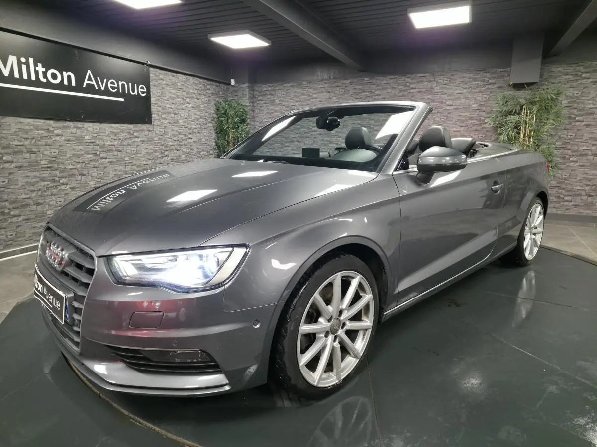 Audi A3 Cabriolet gris métallisé vue 3/4 avant droit avec capote ouverte et jantes sport 18 pouces.