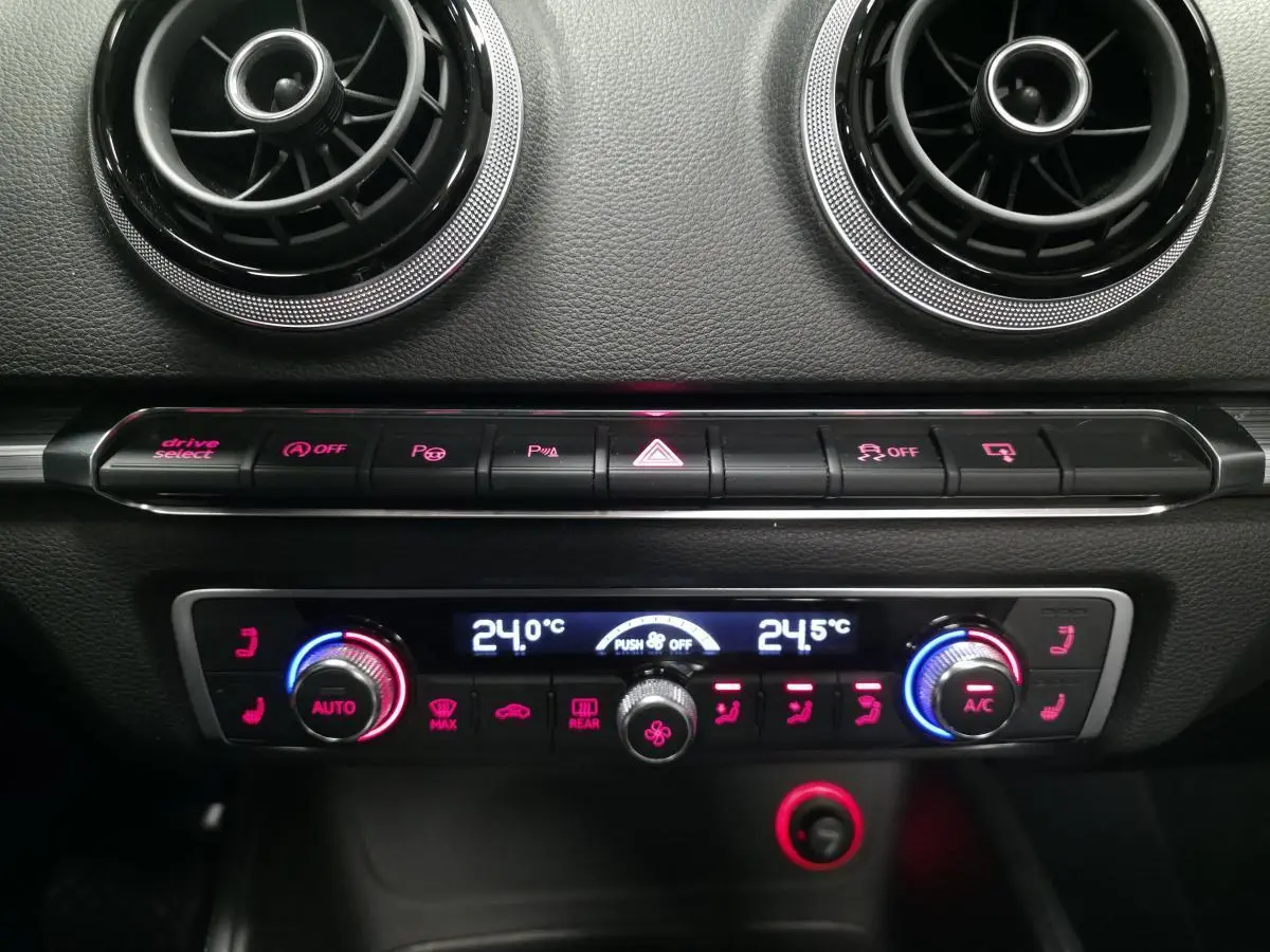 Détail du tableau de bord de l'Audi A3 Cabriolet 2015 montrant la climatisation automatique et les aérateurs ronds noirs.