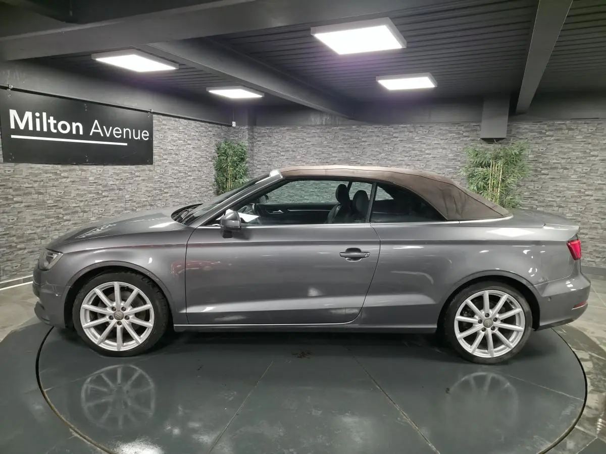 Profil côté gauche d'une Audi A3 Cabriolet gris métallisé avec capote fermée marron, jantes 18 pouces en aluminium.