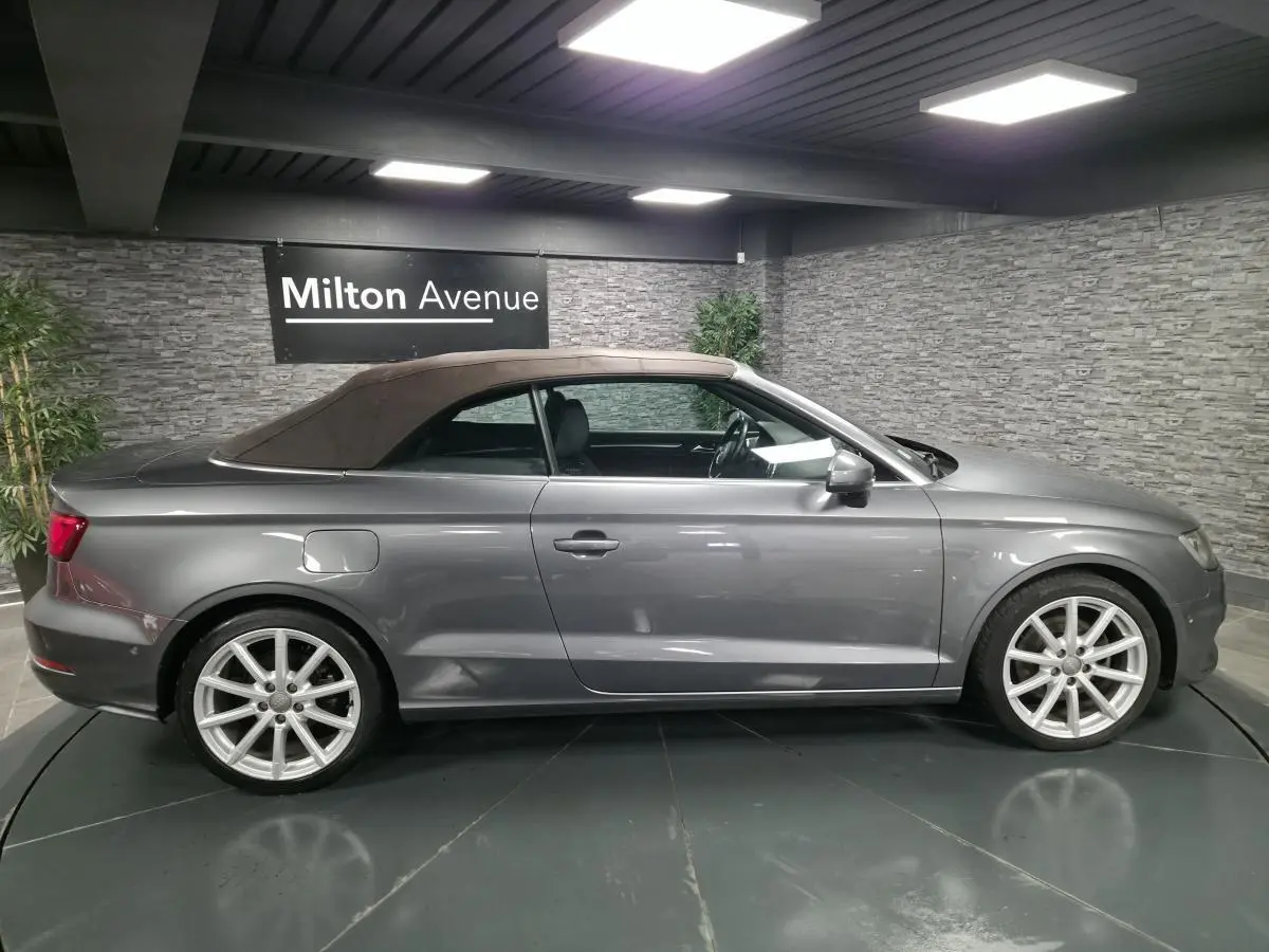 Audi A3 Cabriolet gris vue de profil côté gauche avec capote tissu fermée et jantes sport 18 pouces en aluminium.