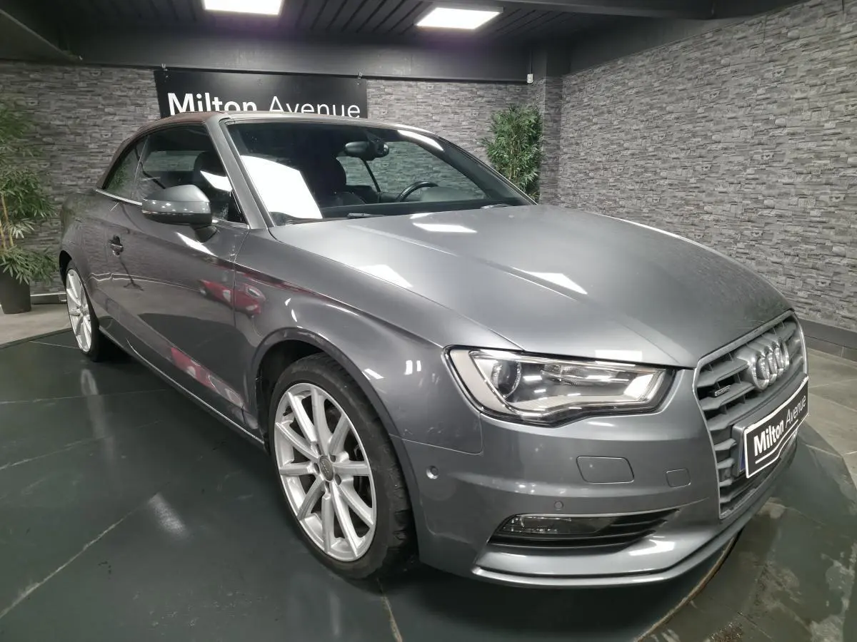 Audi A3 Cabriolet gris en 3/4 avant droit, capote fermée, jantes aluminium 18 pouces et calandre Singleframe chromée.