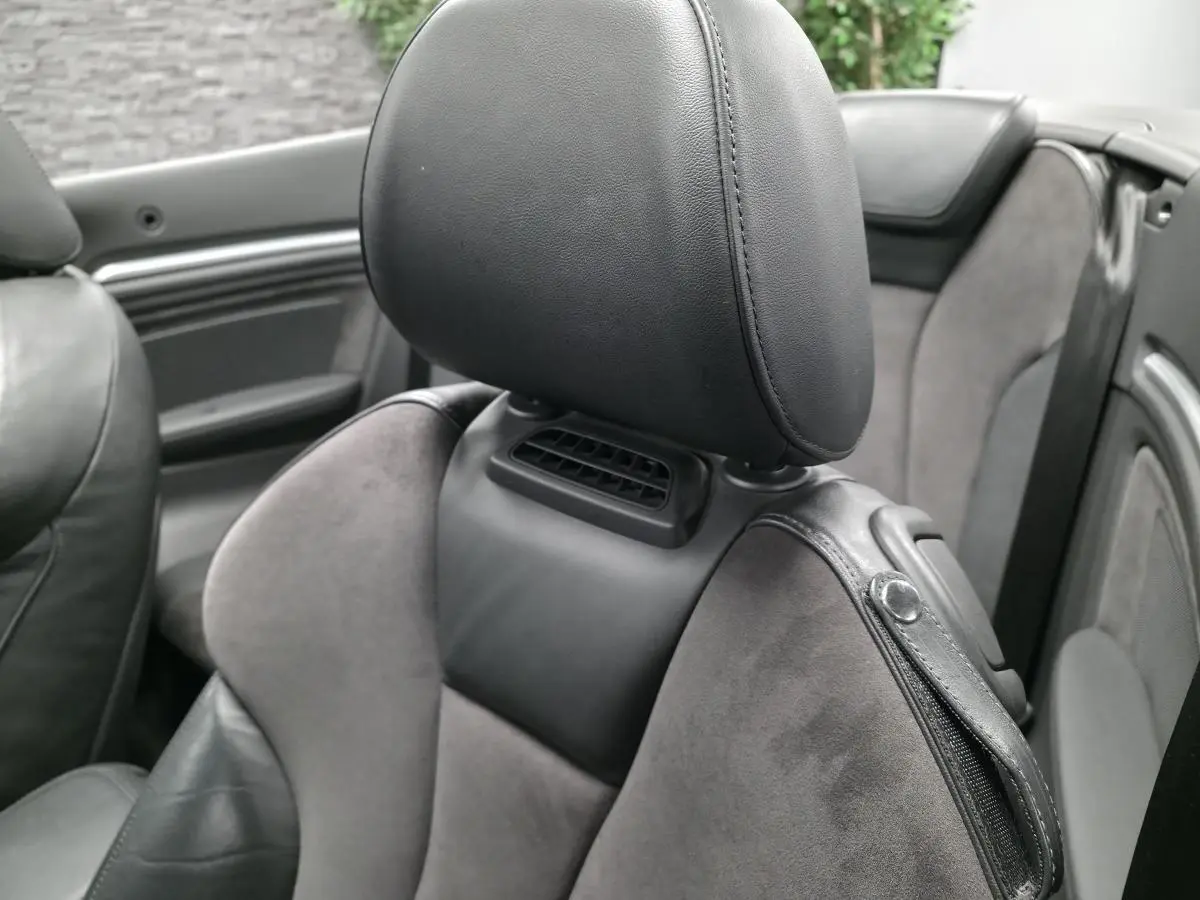 Gros plan sur le siège avant en alcantara et cuir gris foncé de l'Audi A3 Cabriolet 2015, intérieur ouvert.