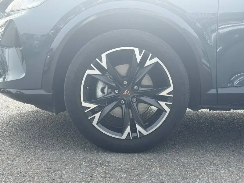 Gros plan sur la roue avant gauche du CUPRA Formentor bleu, avec jante alu noire et argentée au design anguleux.