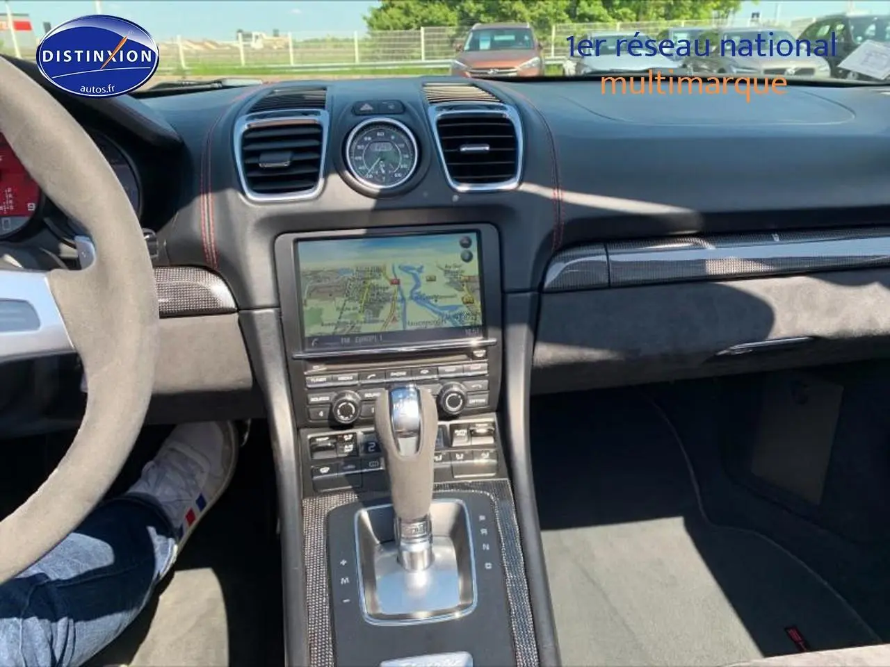 Intérieur noir Alcantara de Porsche Boxster 981 vu du poste de conduite, avec console centrale et écran tactile visible.