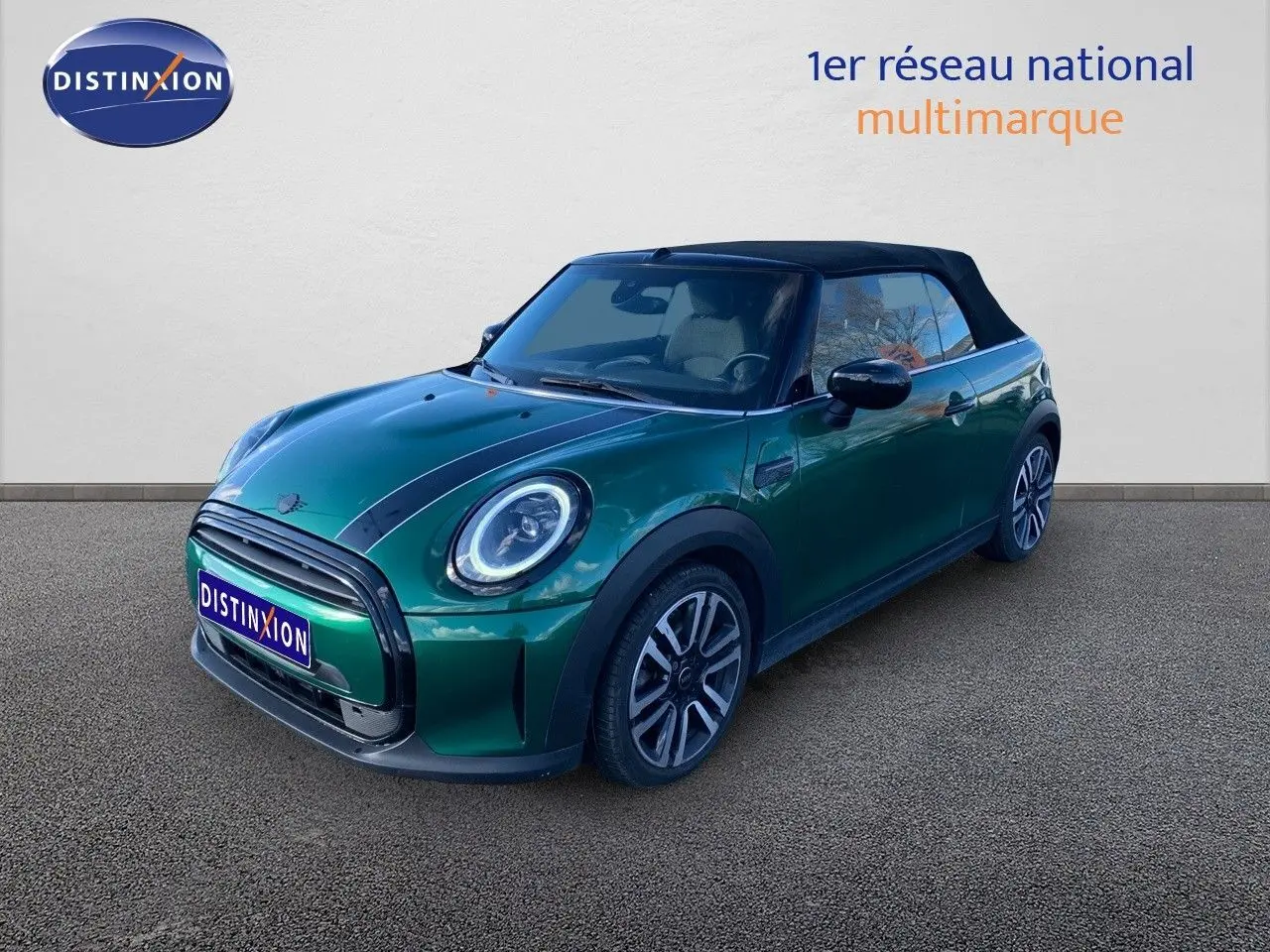 Mini Cabriolet F57 2023 vert British Racing, vue 3/4 avant droit avec capote noire fermée et bandes noires sur le capot.