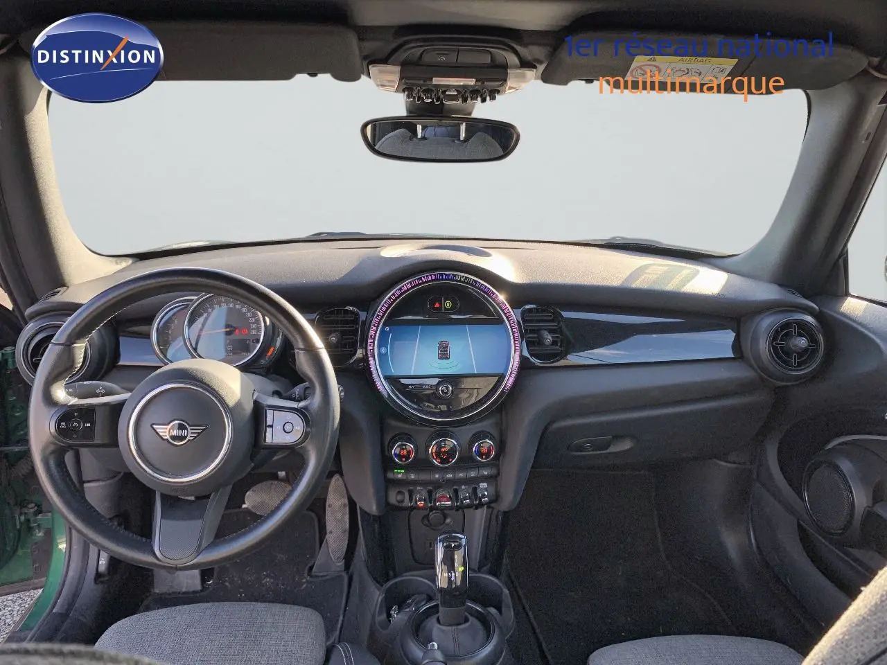 Vue intérieure frontale du tableau de bord et volant noir du MINI Cabriolet F57 vert British Racing 2023.