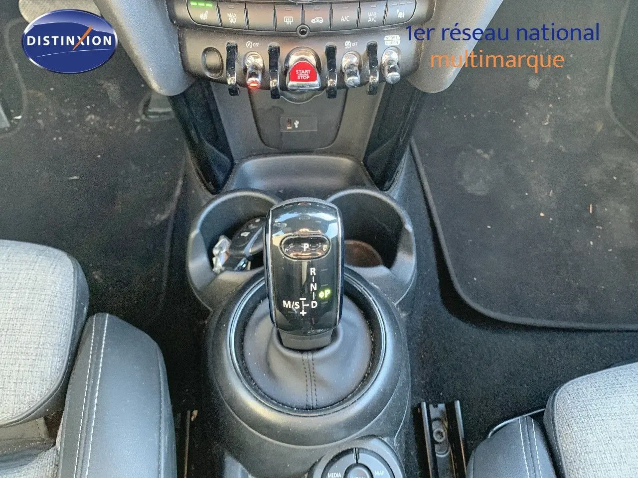 Le levier de vitesses automatique noir de la MINI Cabriolet F57, entouré de porte-gobelets et commandes centrales.