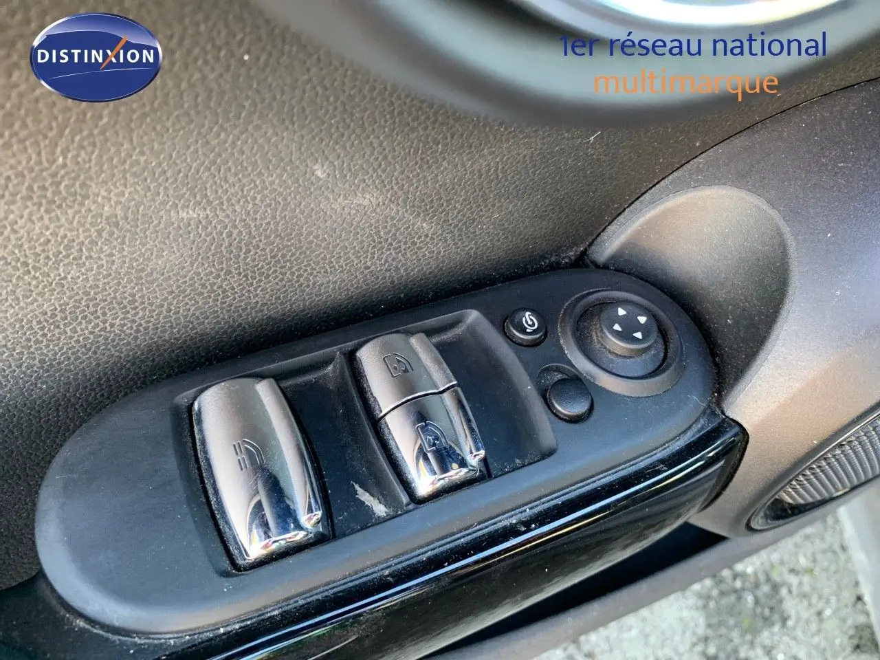 Gros plan sur les commandes de lève-vitres et rétroviseurs côté conducteur d'une MINI Cabriolet F57 British Racing Green 2023.