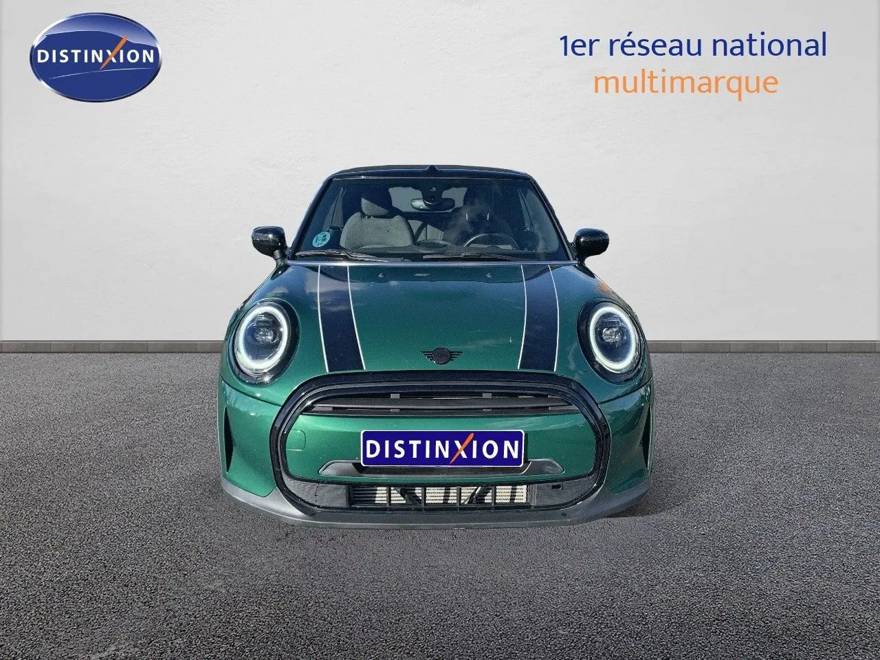 Vue frontale d'une MINI Cabriolet F57 2023 en British Racing Green avec bandes blanches et phares LED ronds.