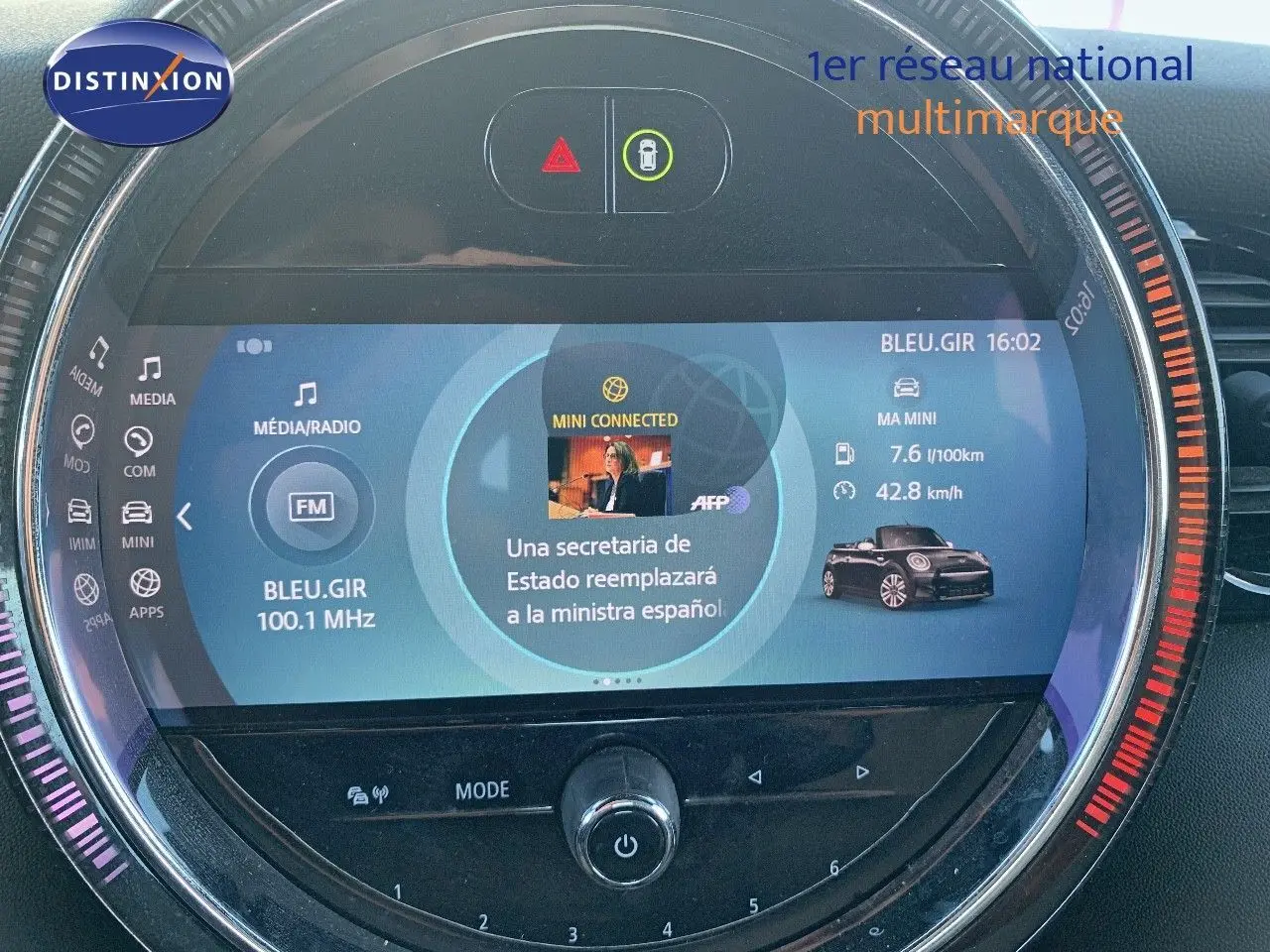 Écran central circulaire de la MINI Cabriolet 2023 en British Racing Green, affichant radio et infos connectées.