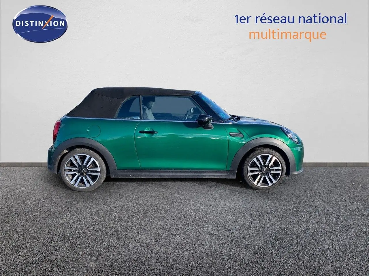 Profil droit d'une MINI Cabriolet F57 2023 British Racing Green avec toit noir fermé et jantes bi-ton.