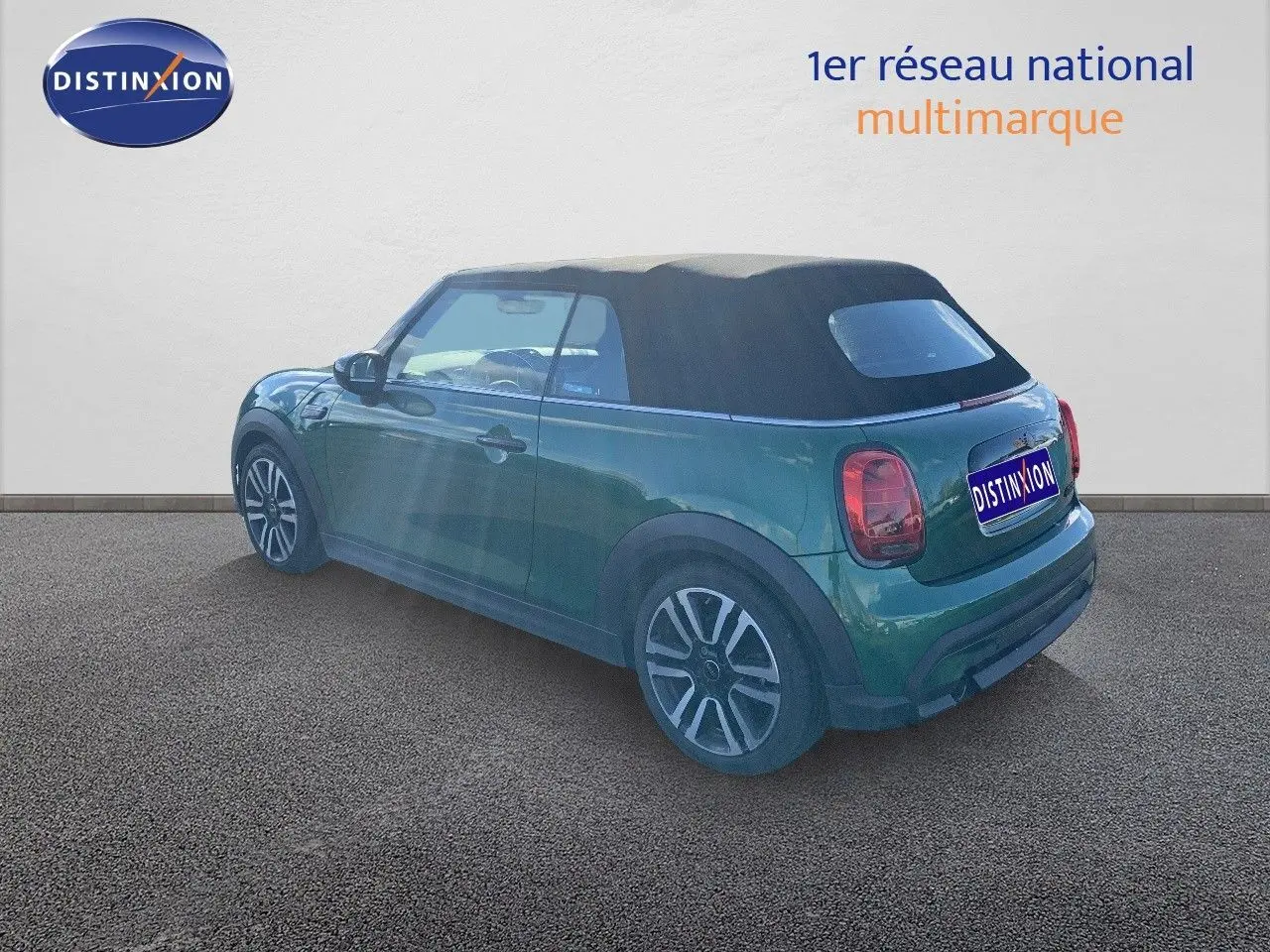 MINI Cabriolet F57 British Racing Green vue 3/4 arrière côté gauche avec toit souple noir fermé.