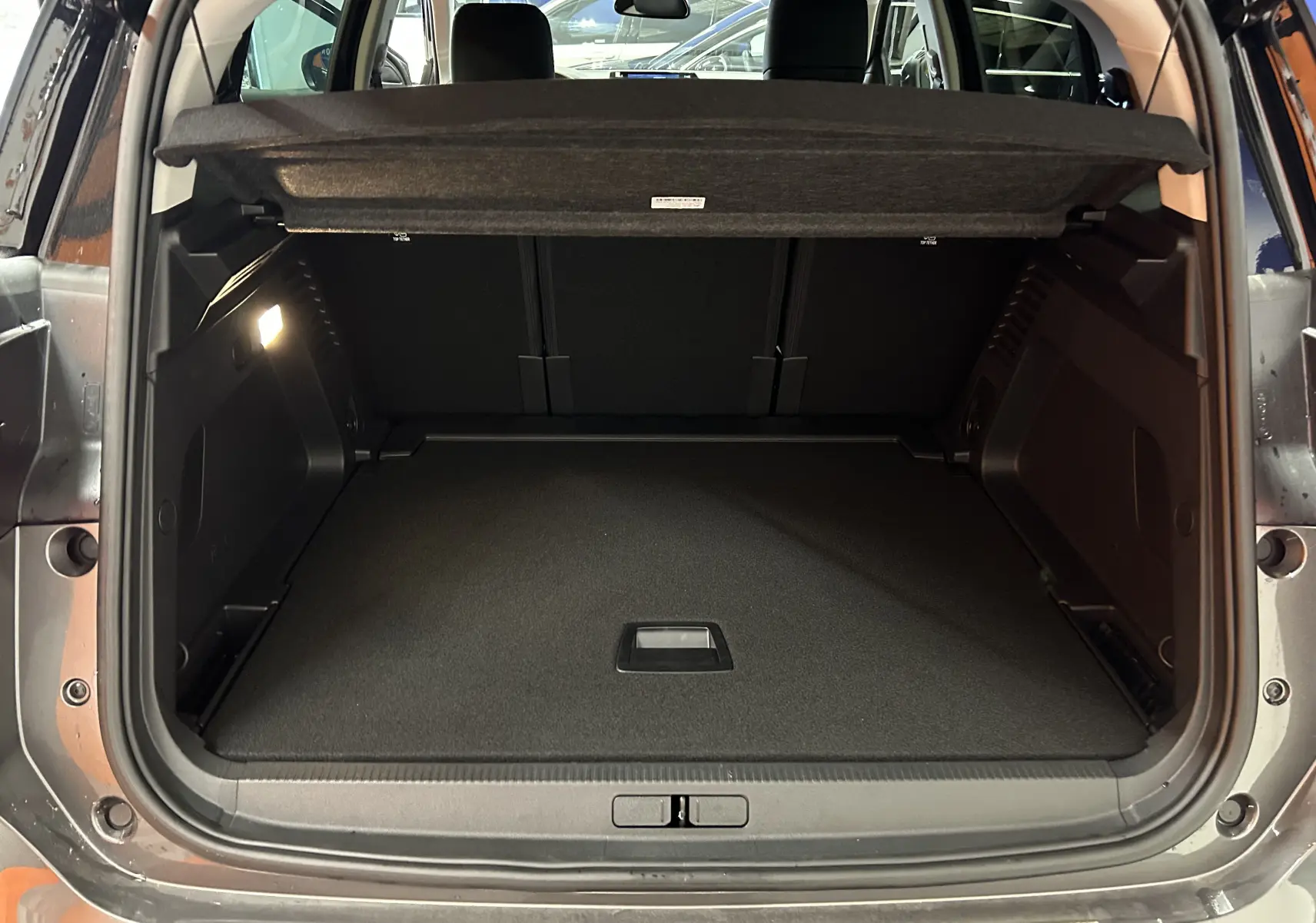 Coffre ouvert du Citroën C5 Aircross gris platinium, vue arrière montrant l'espace de chargement et la tablette cache-bagages.