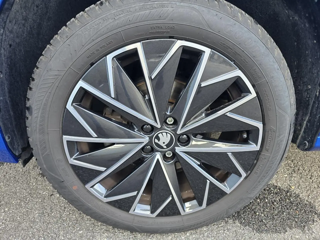 Gros plan sur la jante alliage 17 pouces noire et argentée du Skoda Kamiq bleu racing avec toit noir.