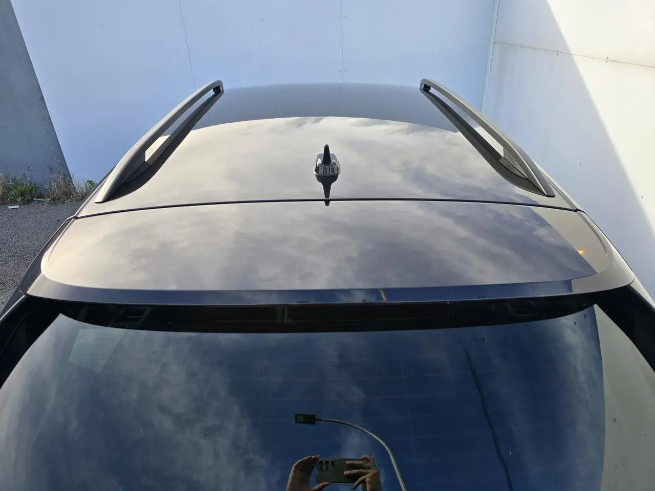 Vue plongeante sur le toit noir brillant et barres de toit du Skoda Kamiq bleu Racing 2025.