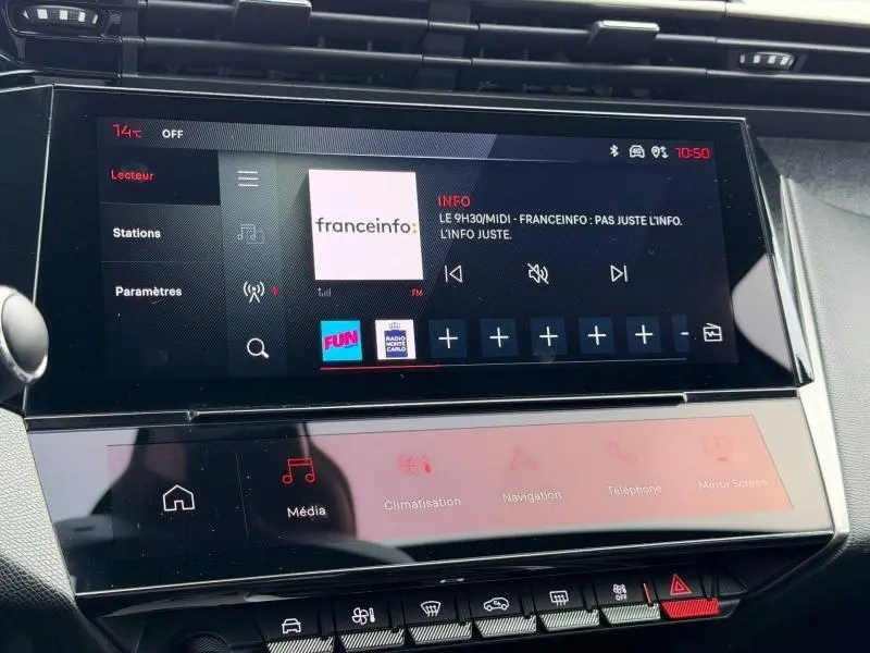 Écran tactile central du tableau de bord de la Peugeot 308 gris 2024, affichant la radio Franceinfo en mode FM.