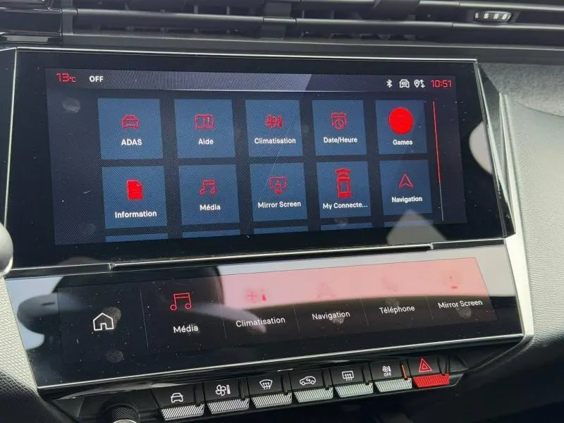 Gros plan sur l’écran tactile central du tableau de bord du Peugeot 308 gris 2024, affichant les menus multimédia et climatisation.