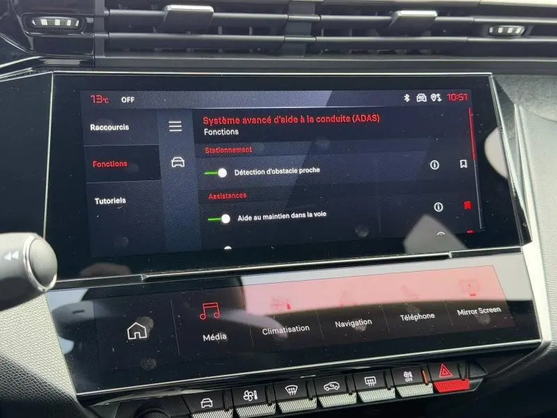 Écran tactile central du tableau de bord de la Peugeot 308 gris 2024 affichant les aides à la conduite avancées.