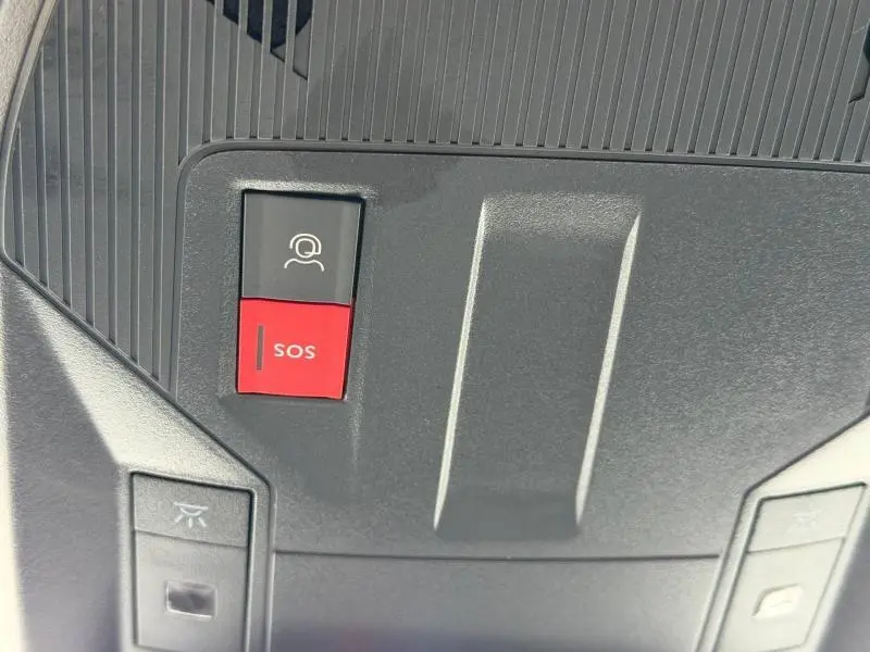 Gros plan sur les boutons SOS et appel d'urgence dans l'habitacle du Peugeot 308 gris 1.2 PureTech 130ch 2024.