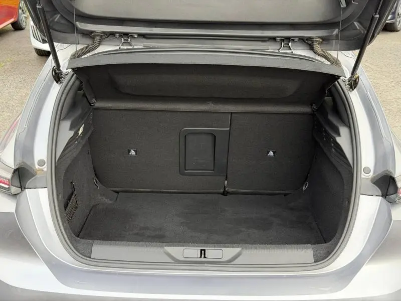 Coffre ouvert vu de l'arrière d'une Peugeot 308 gris 2024, montrant un espace de chargement propre et spacieux.