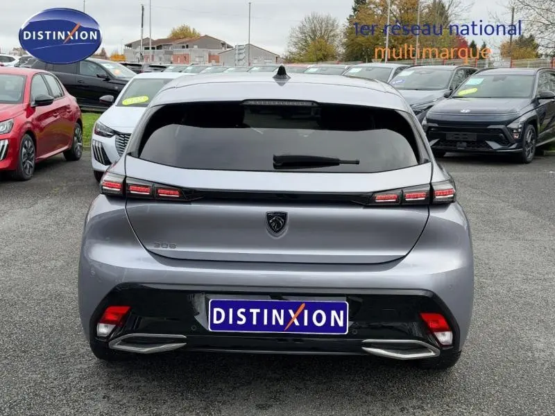 Vue arrière d'une Peugeot 308 gris métallisé 2024 avec feux LED distinctifs et double sortie d'échappement intégrée.