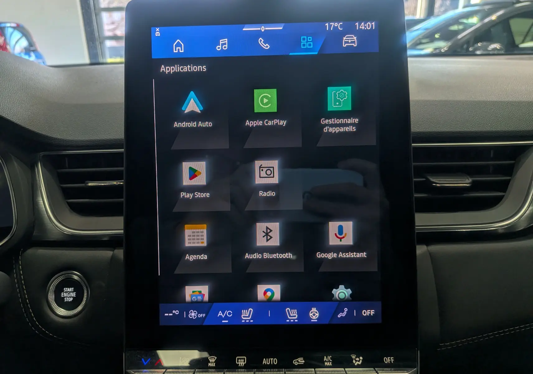 Vue intérieure centrée sur l'écran tactile du tableau de bord du Renault Symbioz gris Cassiopé, affichant les applications connectées.