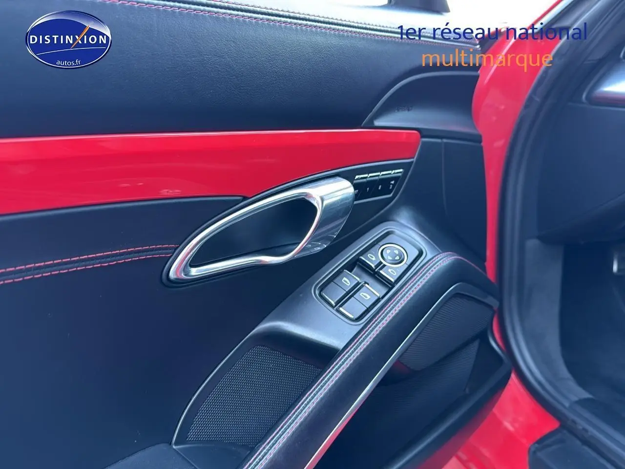 Détail de la porte avant droite rouge de Porsche 911 (991) Carrera 4 PDK avec garniture cuir noire et surpiqûres rouges.