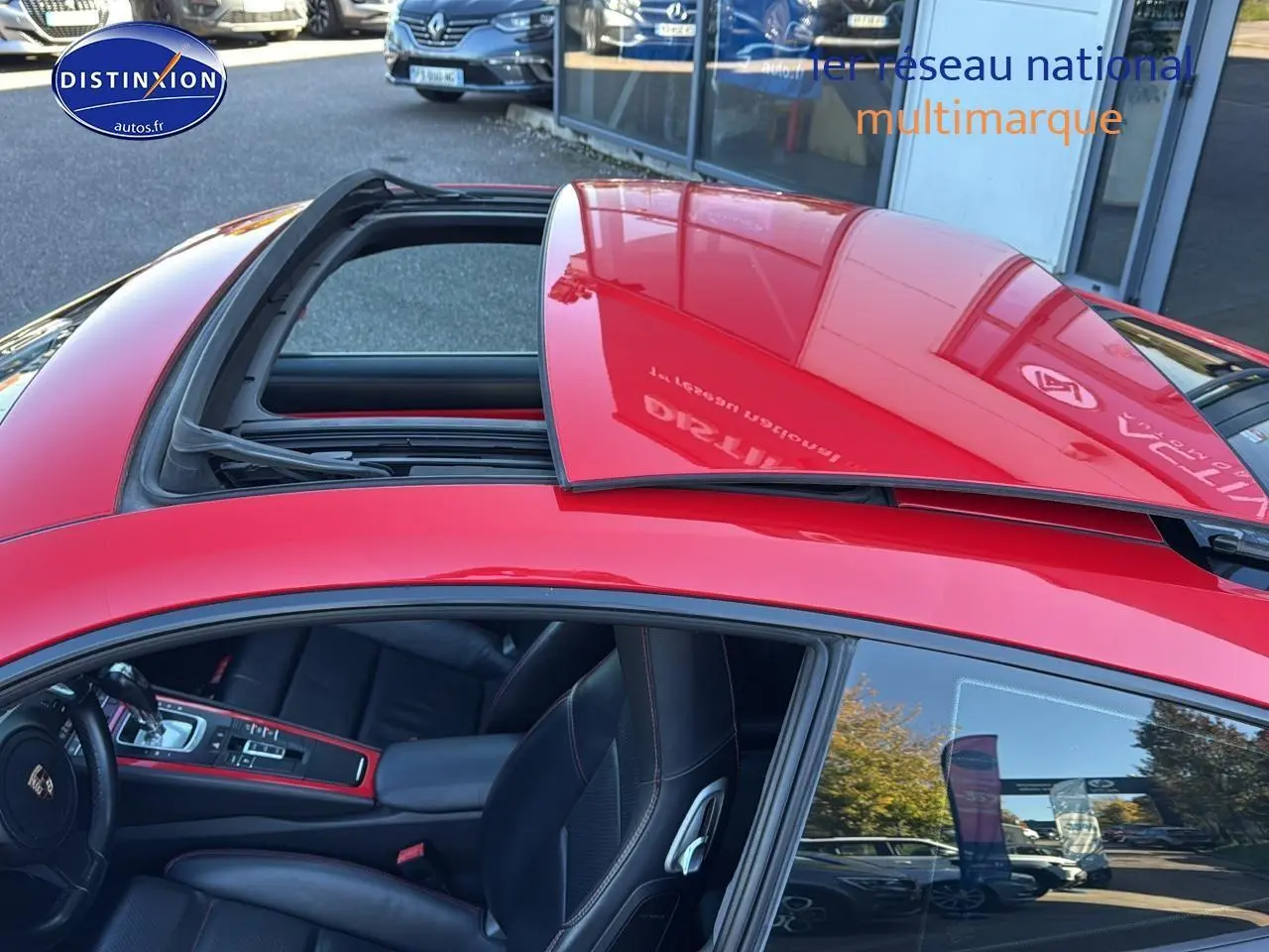Vue de dessus côté gauche d'une Porsche 911 rouge (991) avec toit ouvrant électrique partiellement ouvert.