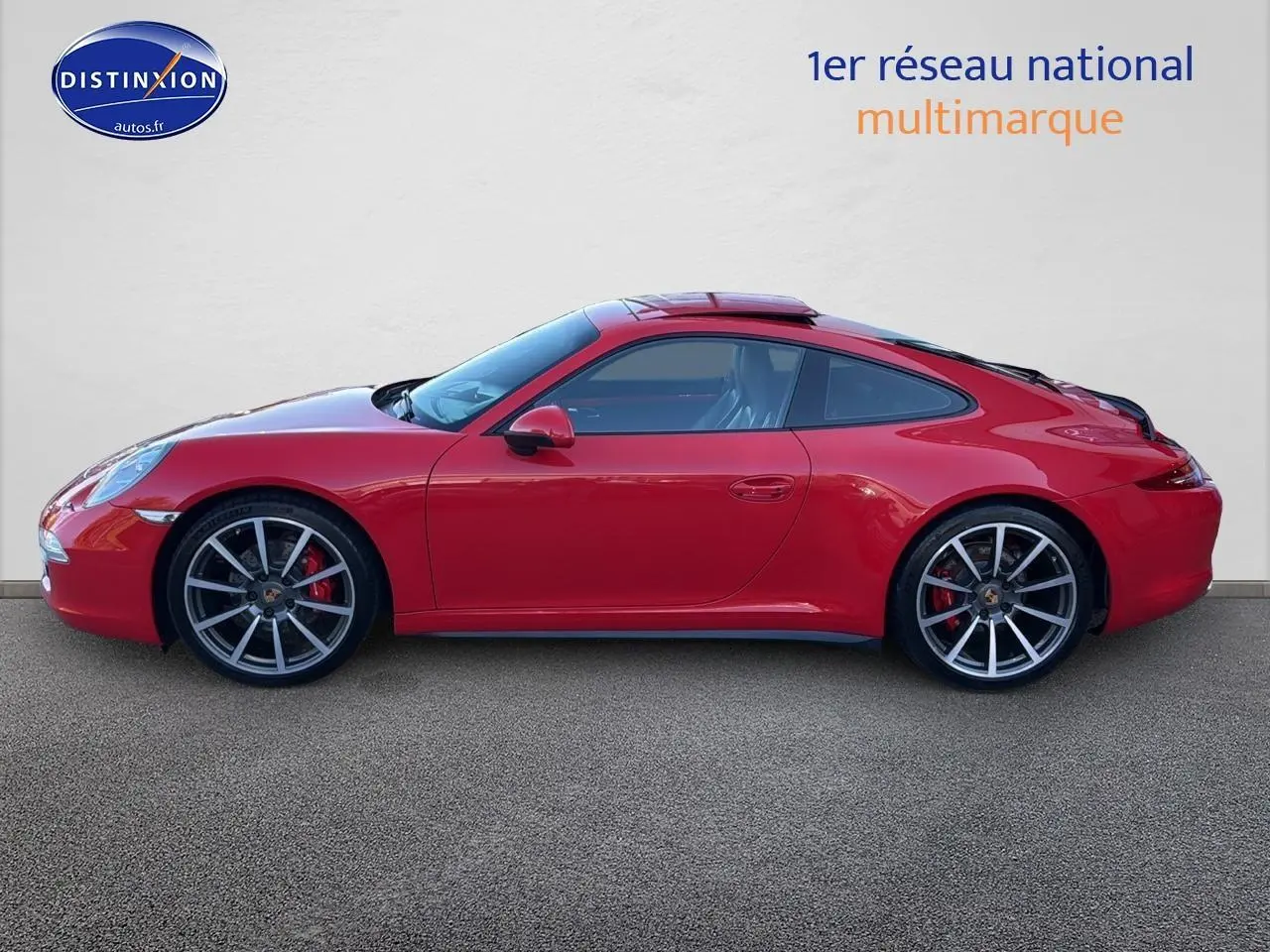 Vue latérale droite d'une Porsche 911 (991) Carrera 4 PDK rouge avec jantes alu et toit ouvrant électrique.