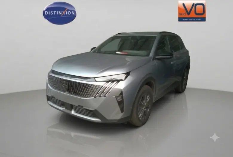 Peugeot 5008 gris en 3/4 avant droit, avec calandre distinctive et jantes alliage 18 pouces visibles.
