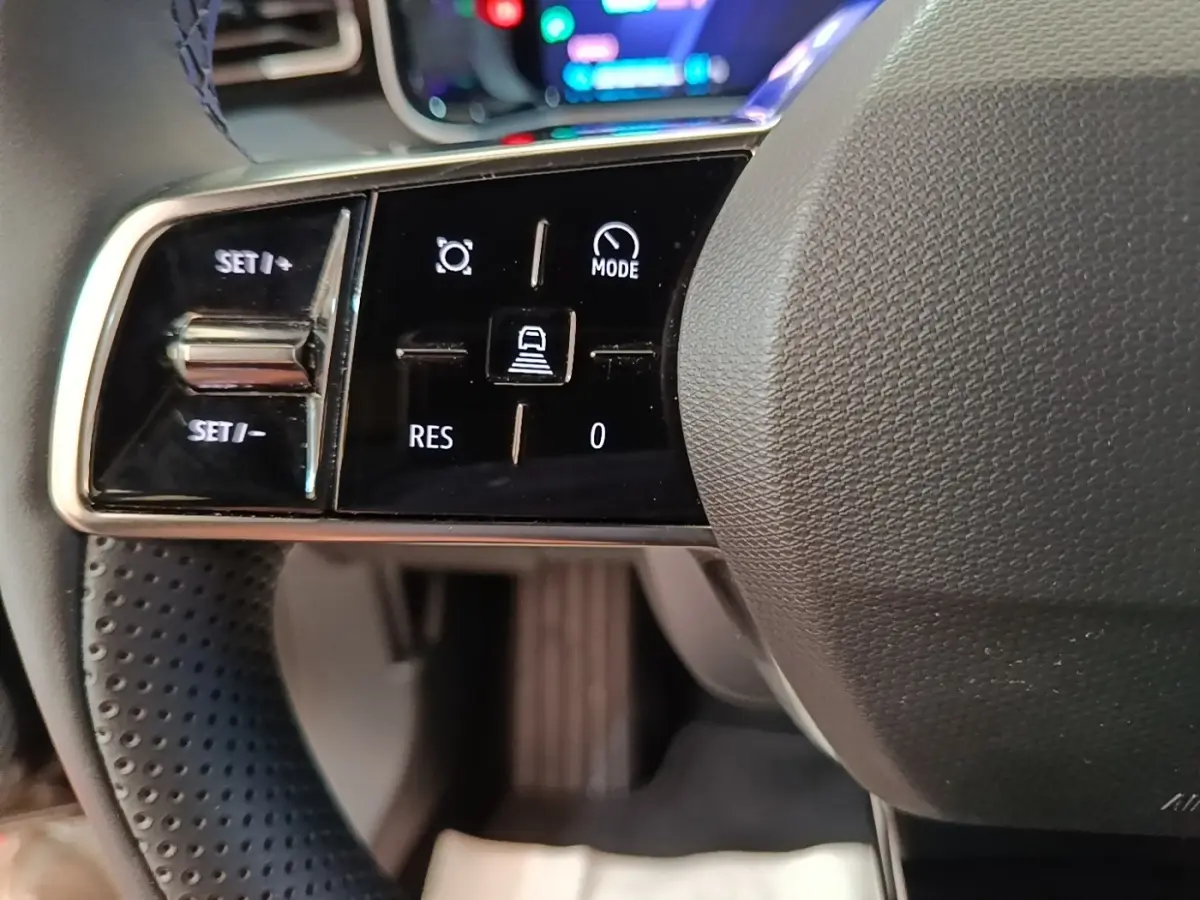Gros plan sur les commandes noires et chromées du volant de la Renault R5 électrique 2024, côté gauche.