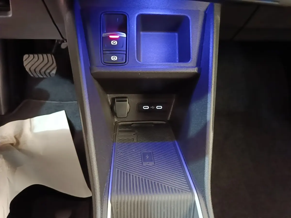 Vue rapprochée de la console centrale intérieure de la Renault R5 électrique 2024, avec chargeur sans fil et ports USB.