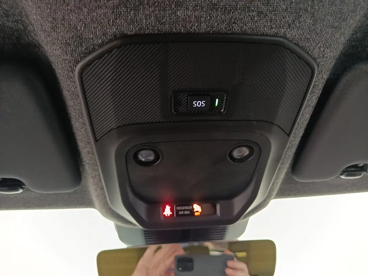 Vue intérieure du plafonnier avec bouton SOS et voyants d'airbag du Renault R5 Iconic 2024, finition carbone.