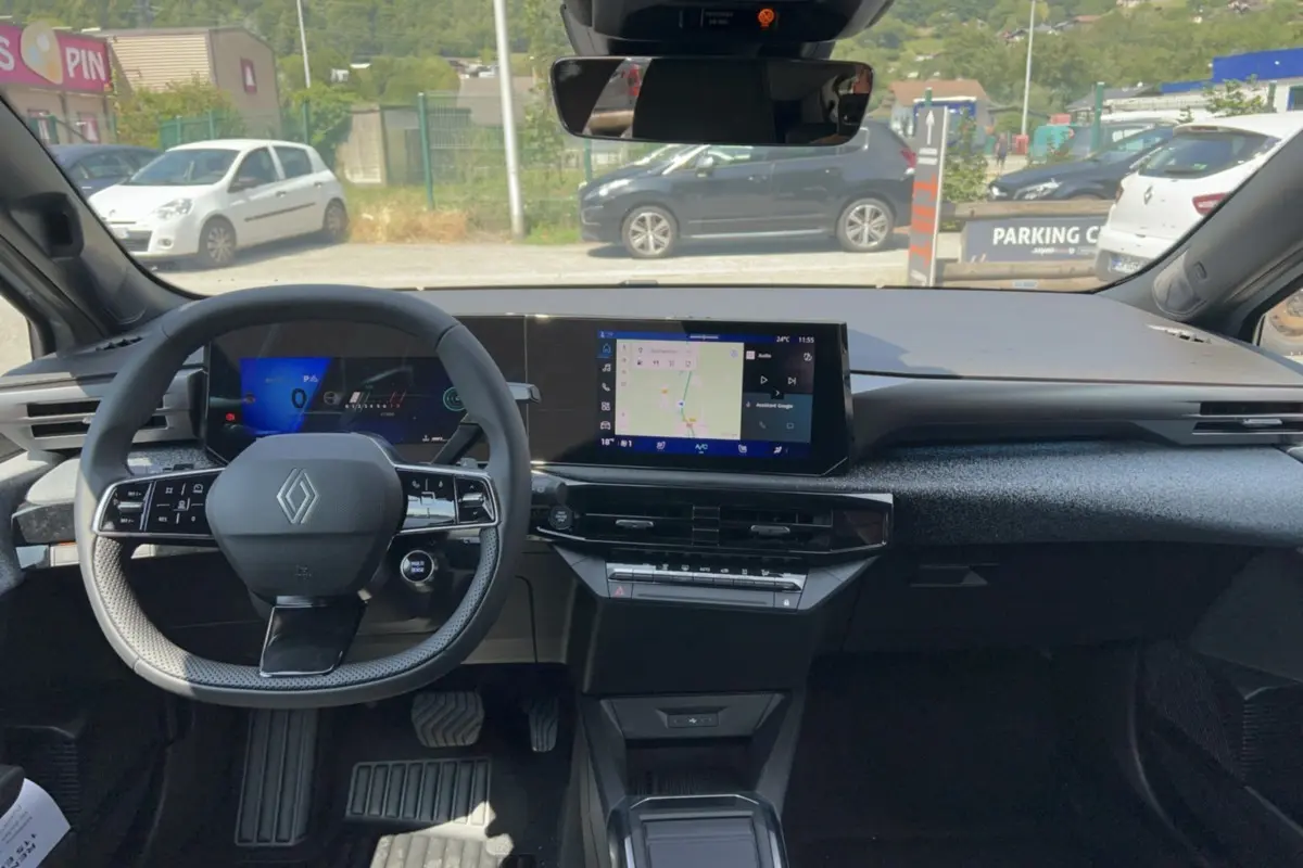 Vue intérieure avant de la Renault Clio gris rafale 2026, avec tableau de bord numérique et écran central tactile.
