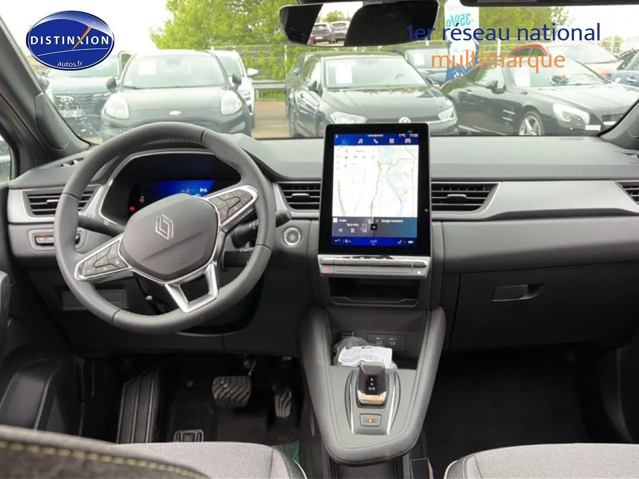 Vue intérieure avant de la Renault Symbioz gris schiste, avec écran tactile vertical et volant multifonctions.