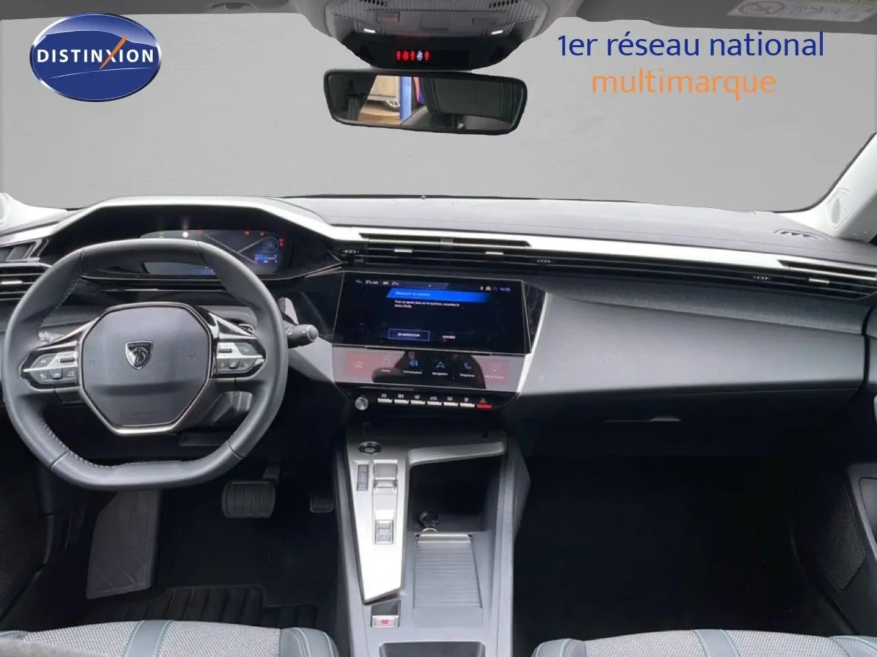 Vue intérieure frontale du tableau de bord et volant de la Peugeot 408 gris, avec écran tactile central et commandes modernes.