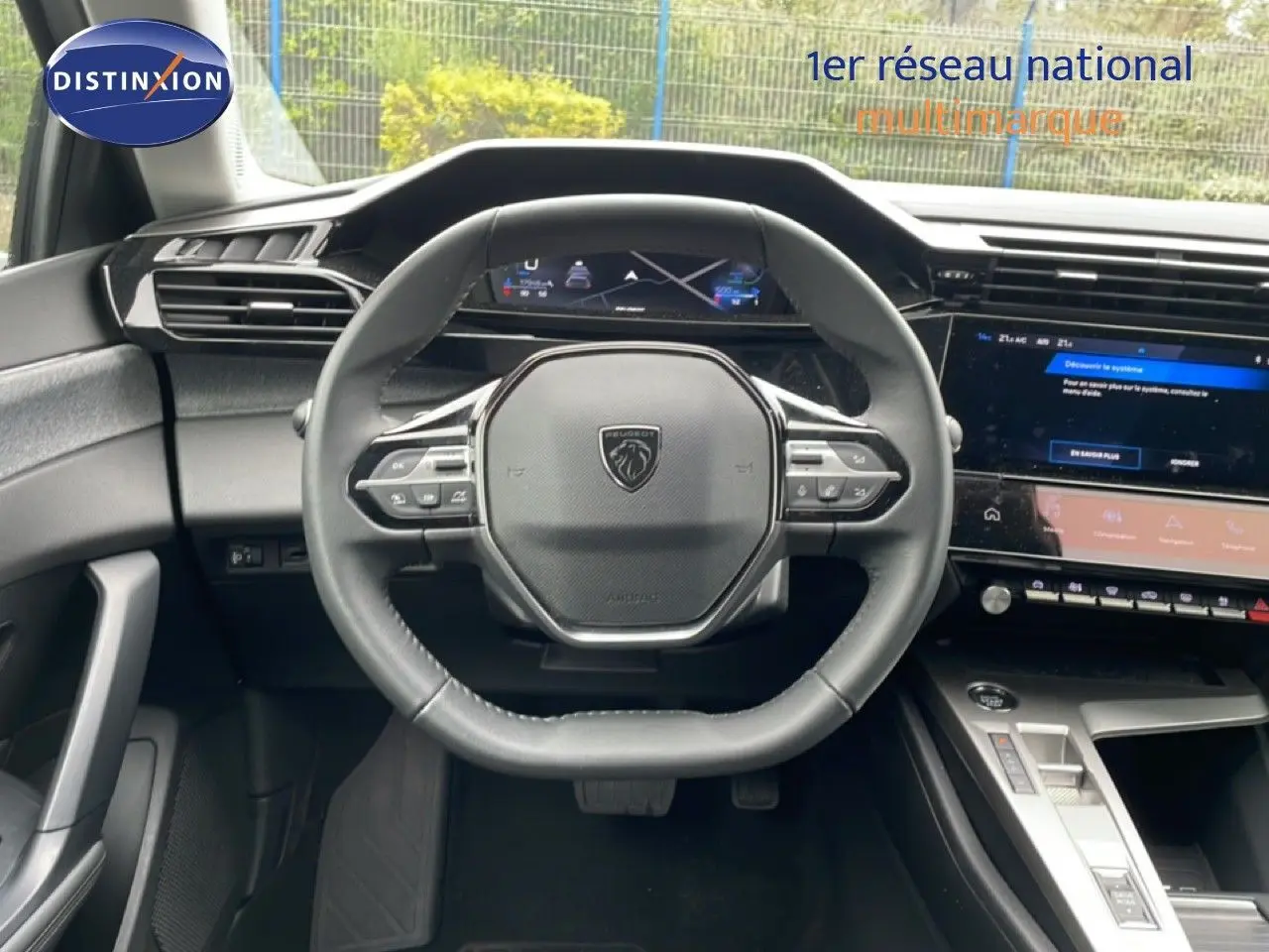 Vue intérieure centrée sur le volant multifonction de la Peugeot 408 1.2 Hybrid 2025 avec tableau de bord numérique.