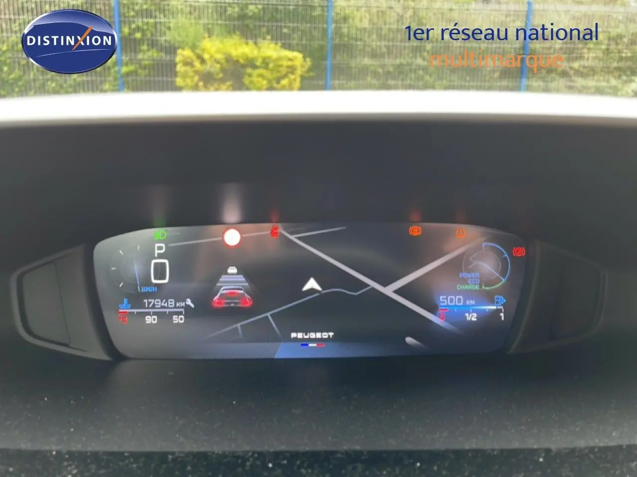 Tableau de bord numérique de Peugeot 408 gris, affichant la vitesse, navigation et alertes, vue frontale intérieure.