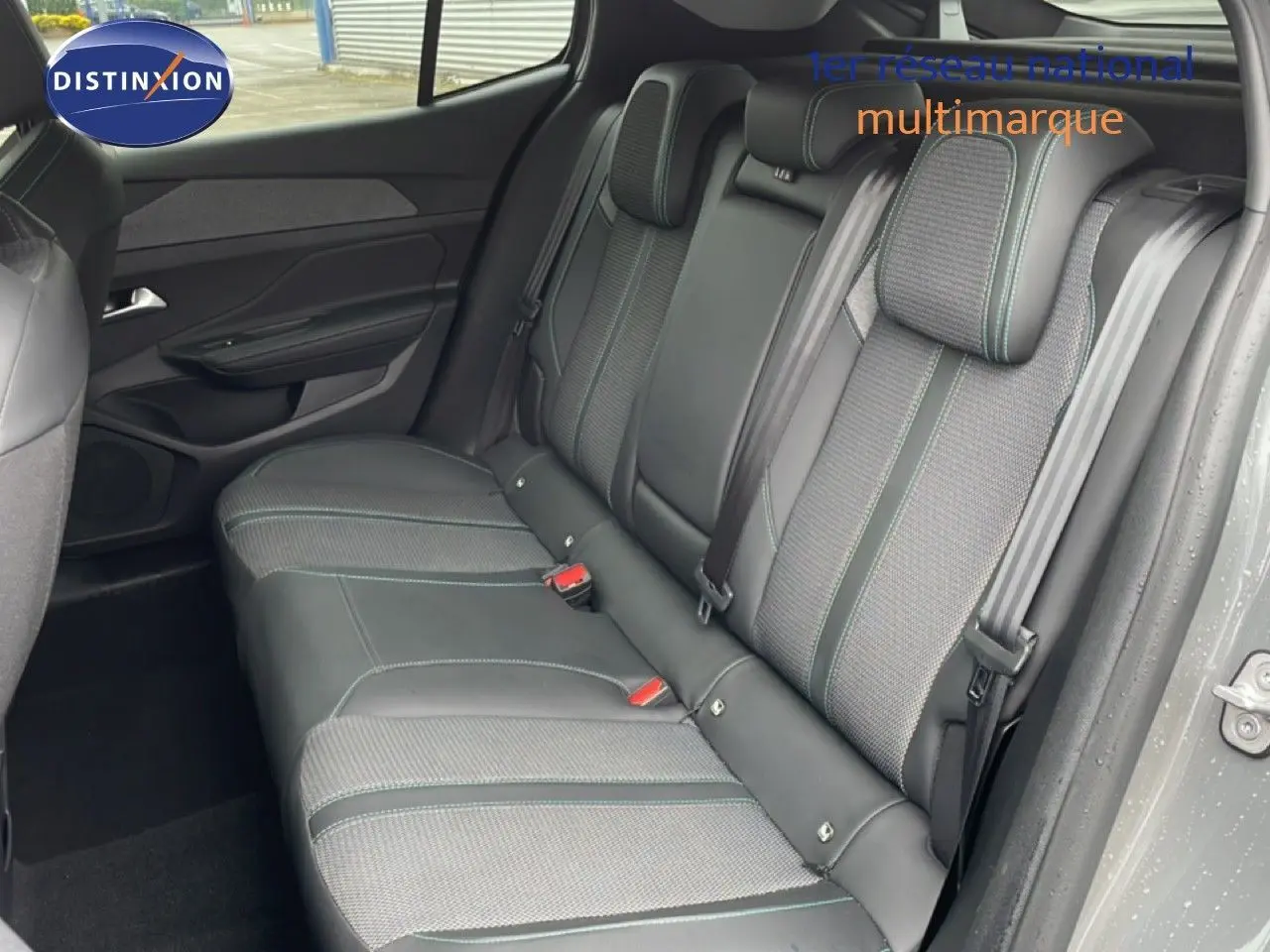 Vue intérieure côté droit des sièges arrière en tissu et cuir gris noir de la Peugeot 408 1.2 Hybrid 145ch 2025.
