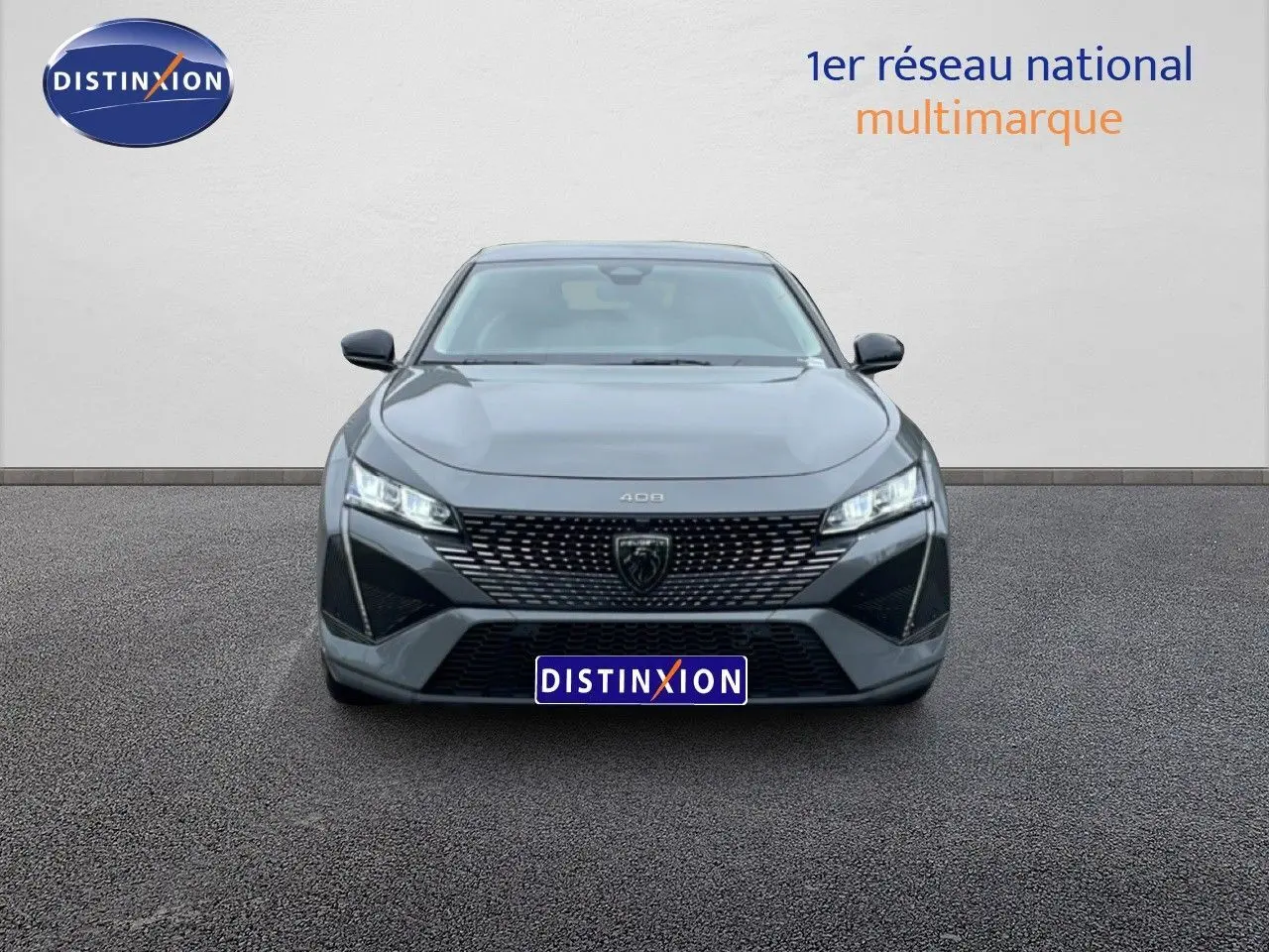 Vue frontale d'une Peugeot 408 gris selenium metal avec calandre noire et phares LED allumés.