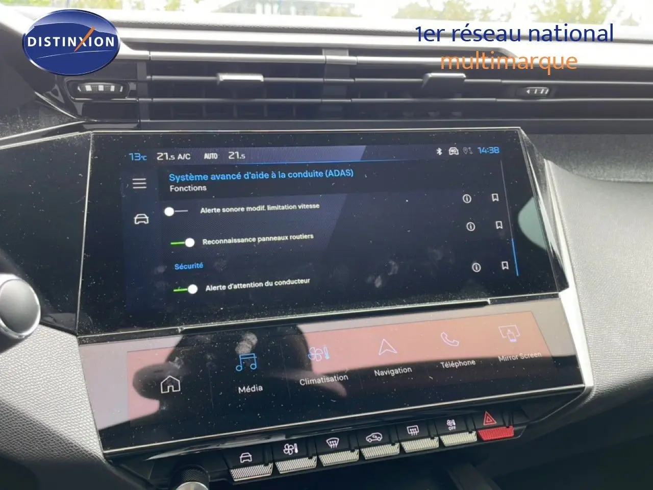Vue rapprochée de l'écran tactile central du tableau de bord de la Peugeot 408 gris selenium, affichant les aides à la conduite.